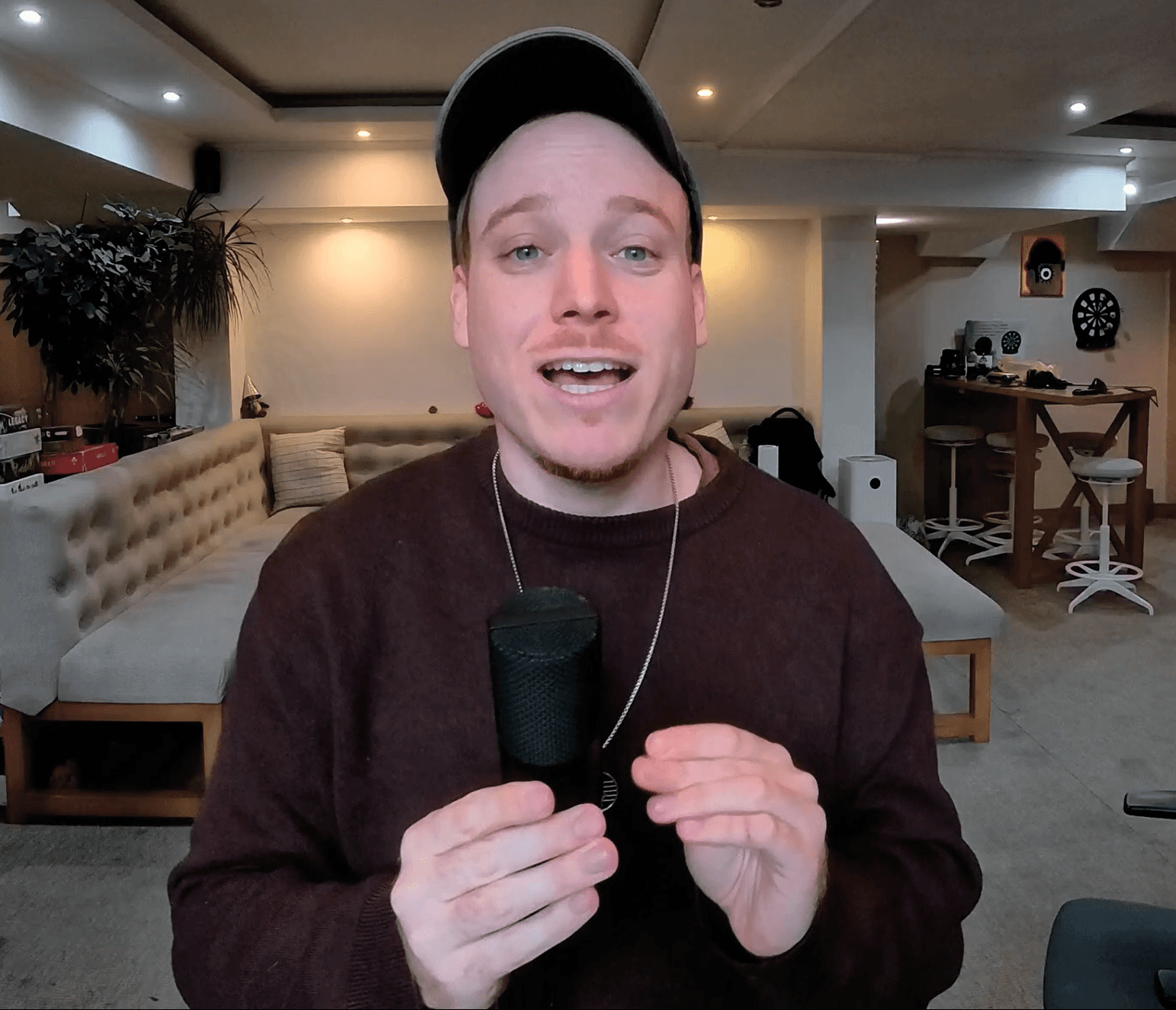 Finch speaking directly to camera with a microphone
